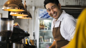 Happy barista man working in cafe